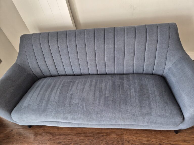 Grey fabric sofa after professional upholstery cleaning with visible extraction lines