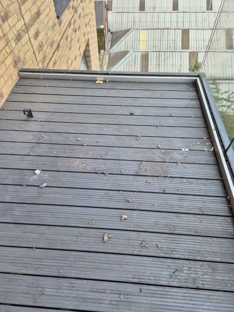 Composite decking balcony with visible dirt, debris and surface marks before professional cleaning