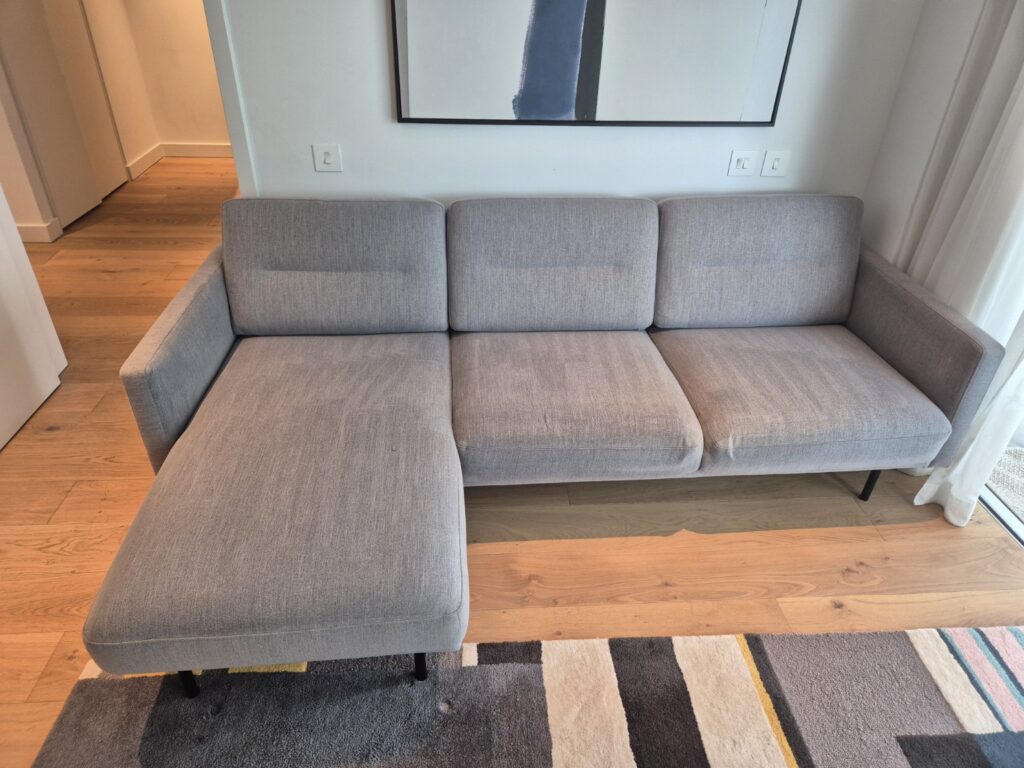 Grey fabric sectional sofa after professional upholstery cleaning, showing refreshed fabric and visible extraction lines